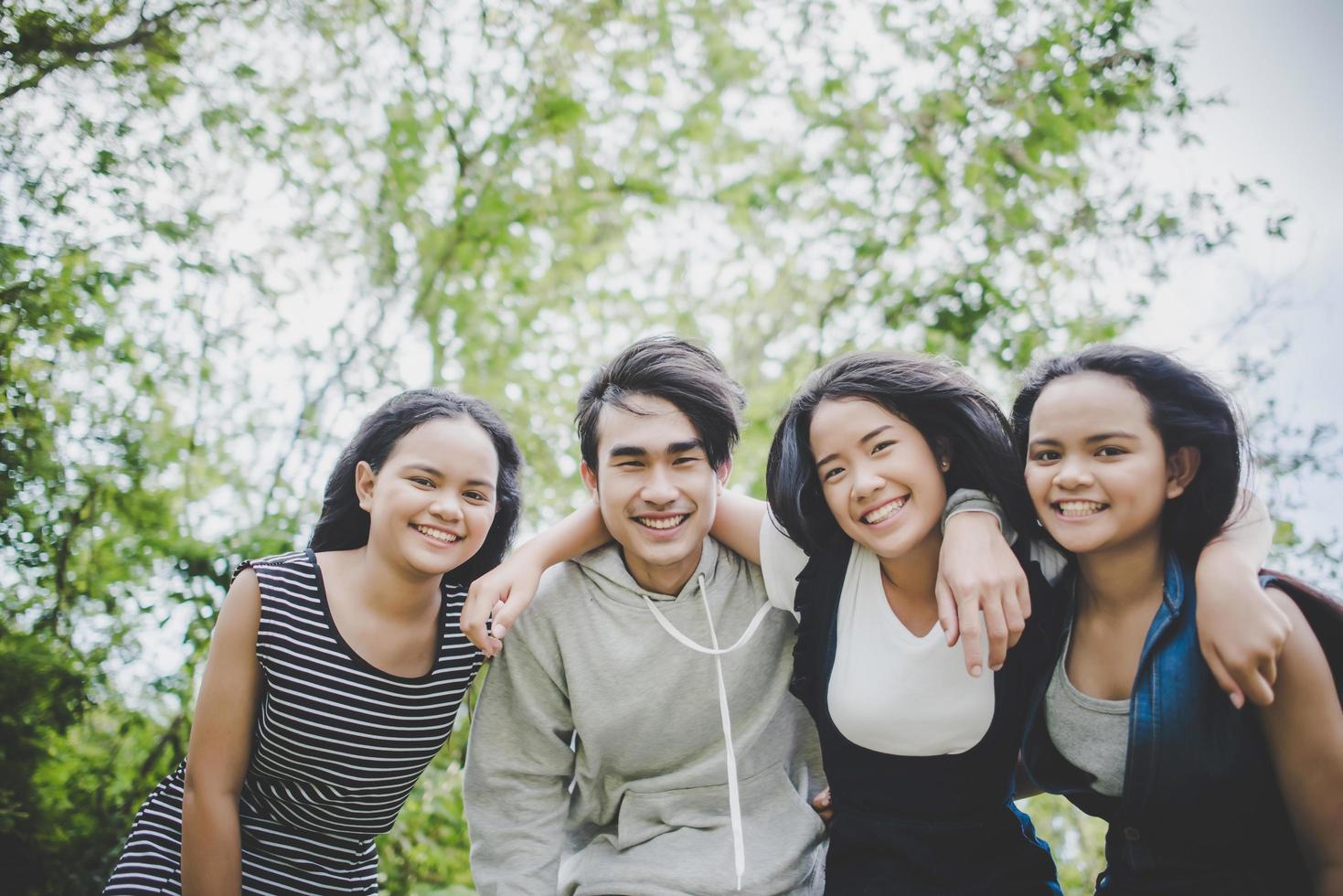 Happy teenage friends smiling outdoors at a park photo