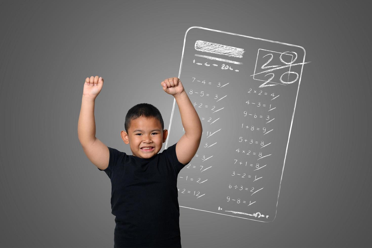 Young boy shows full marks in school tests on the blackboard photo