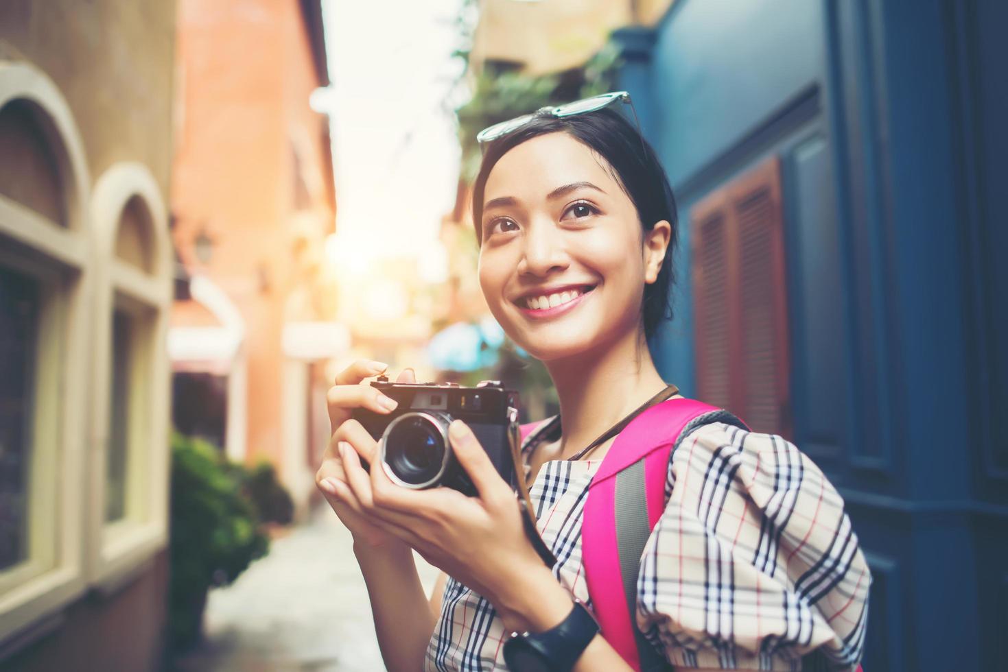 Primer plano de una joven inconformista viajando y tomando fotos con su cámara