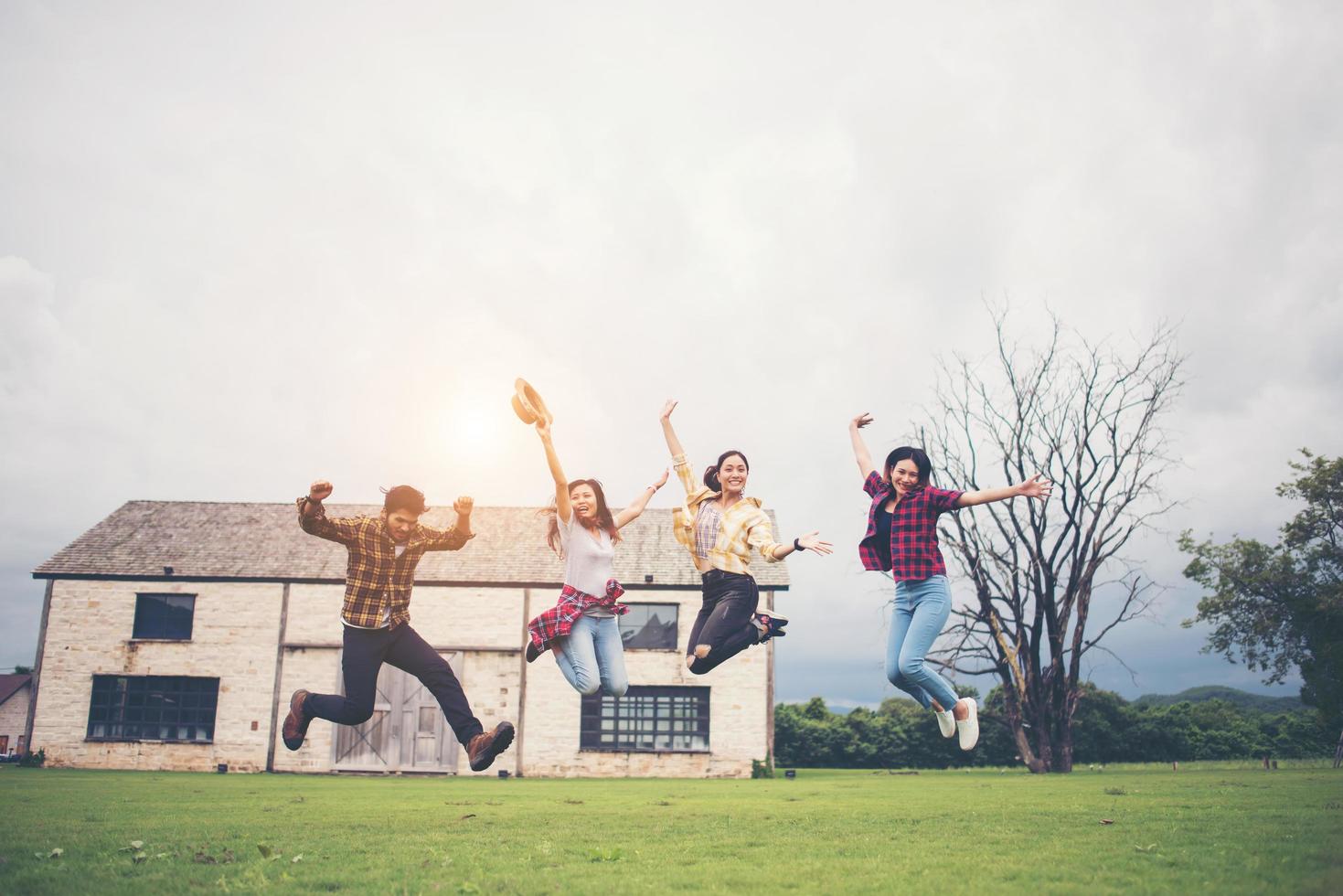 Happy group of teen students jumping in a park together photo