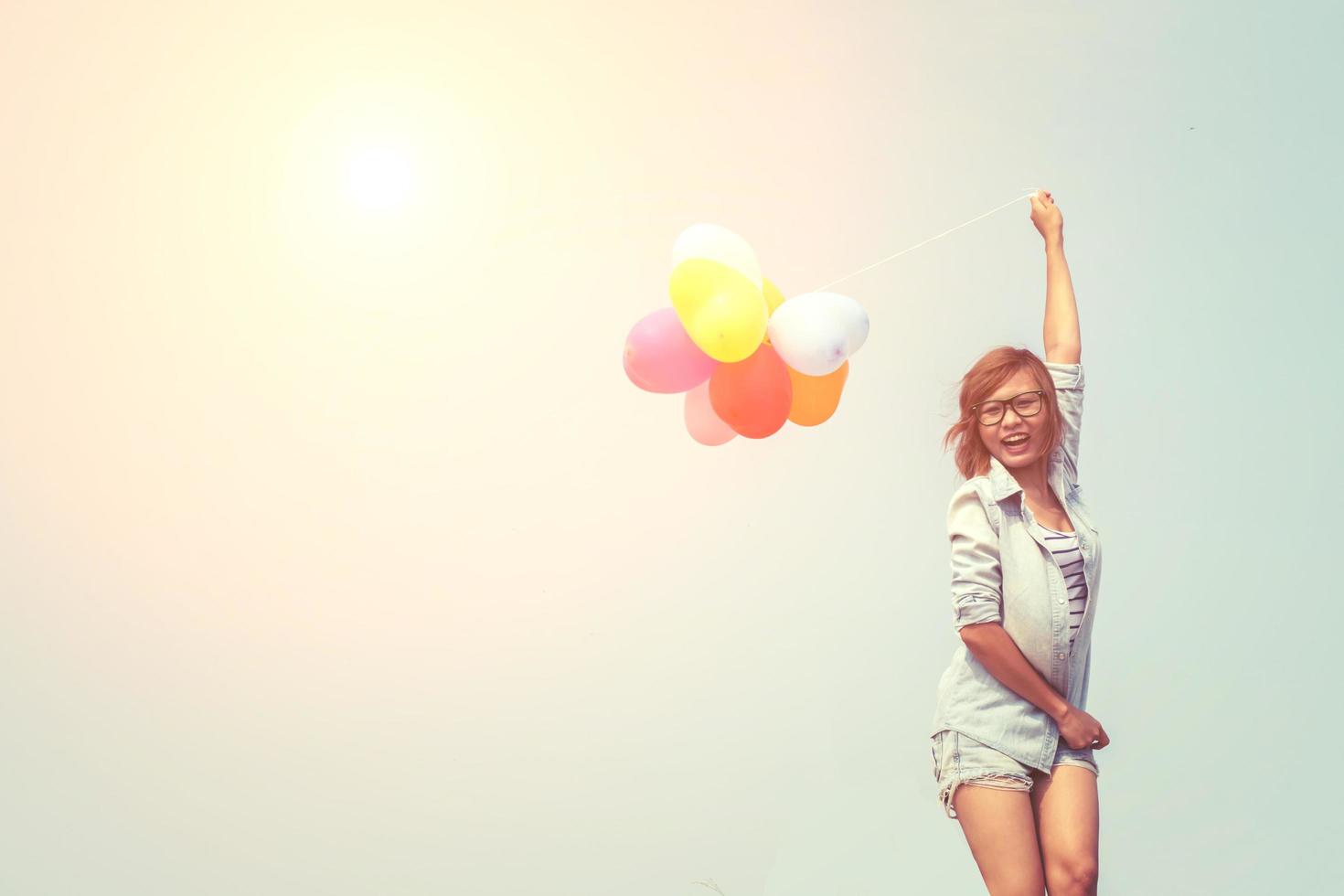 joven y bella mujer sosteniendo globos al aire libre foto