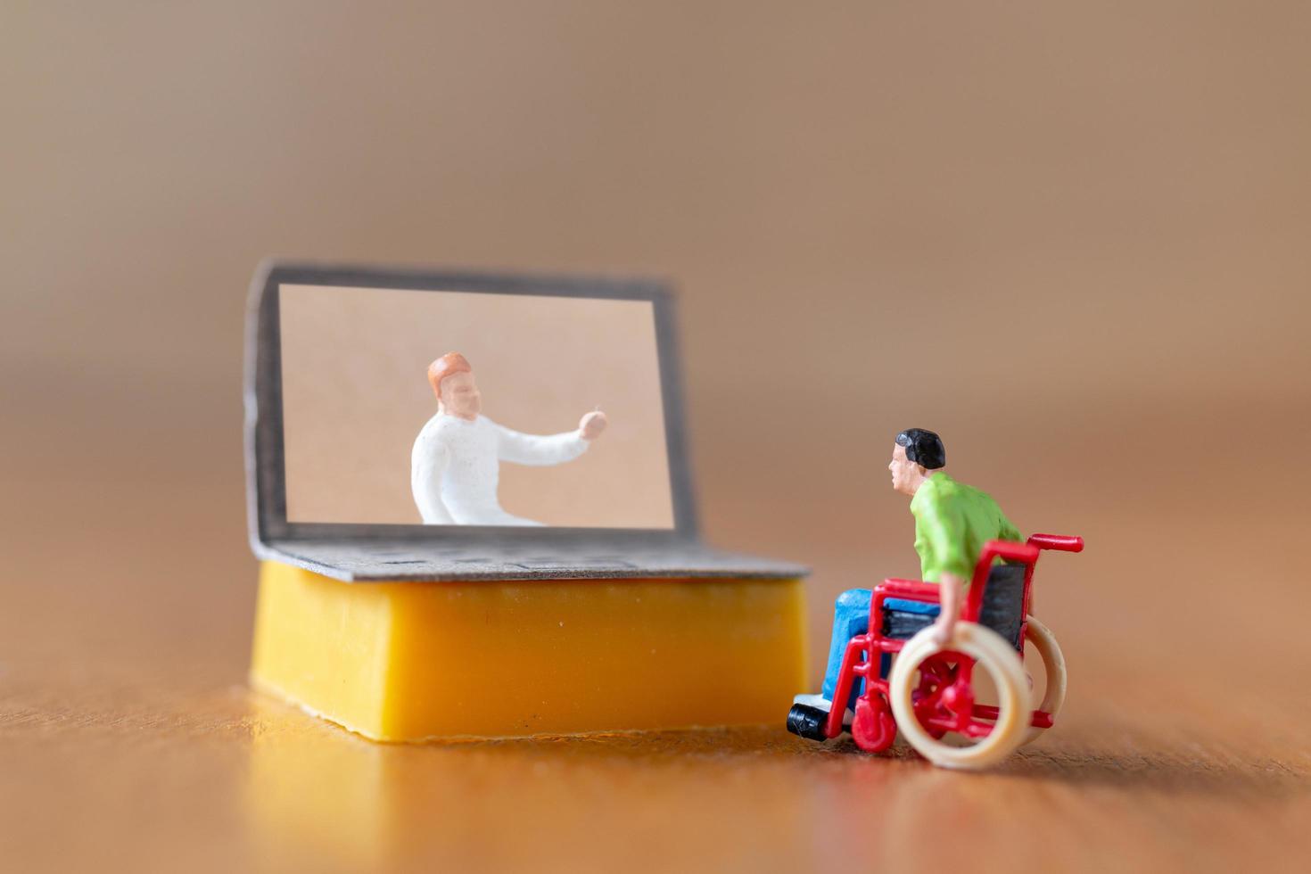 Male figurine patient consulting with doctor using video call on laptop photo