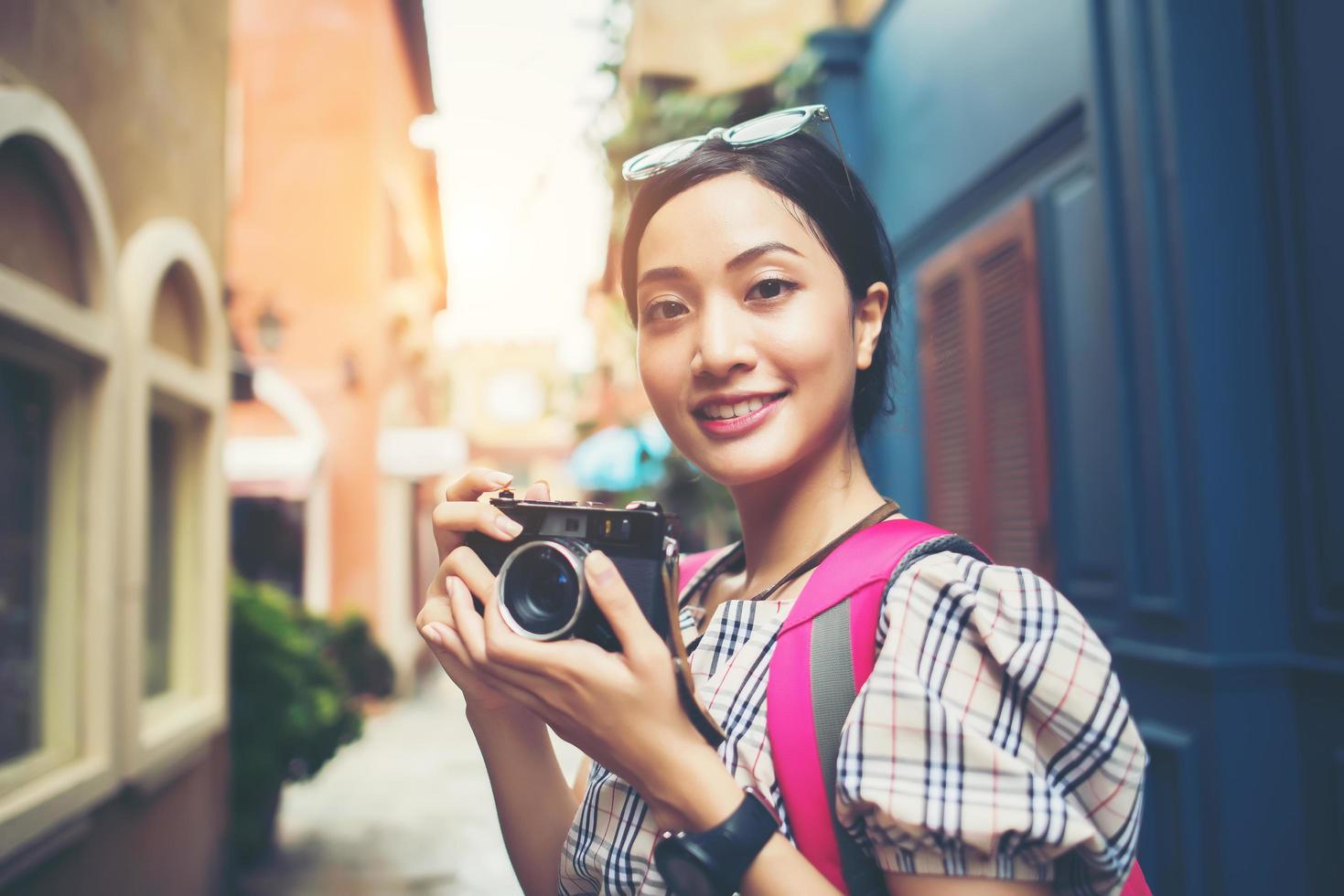 primer plano, de, un, joven, hipster, mujer, mochilero, y, tomar fotos, en, un, área urbana foto