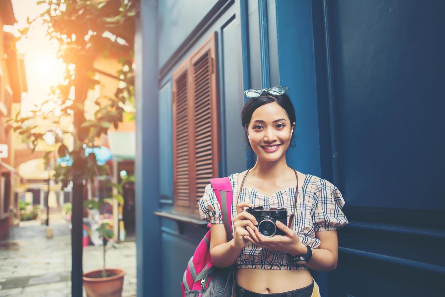 Retrato de mujer bastante joven hipster divirtiéndose en la ciudad con cámara foto