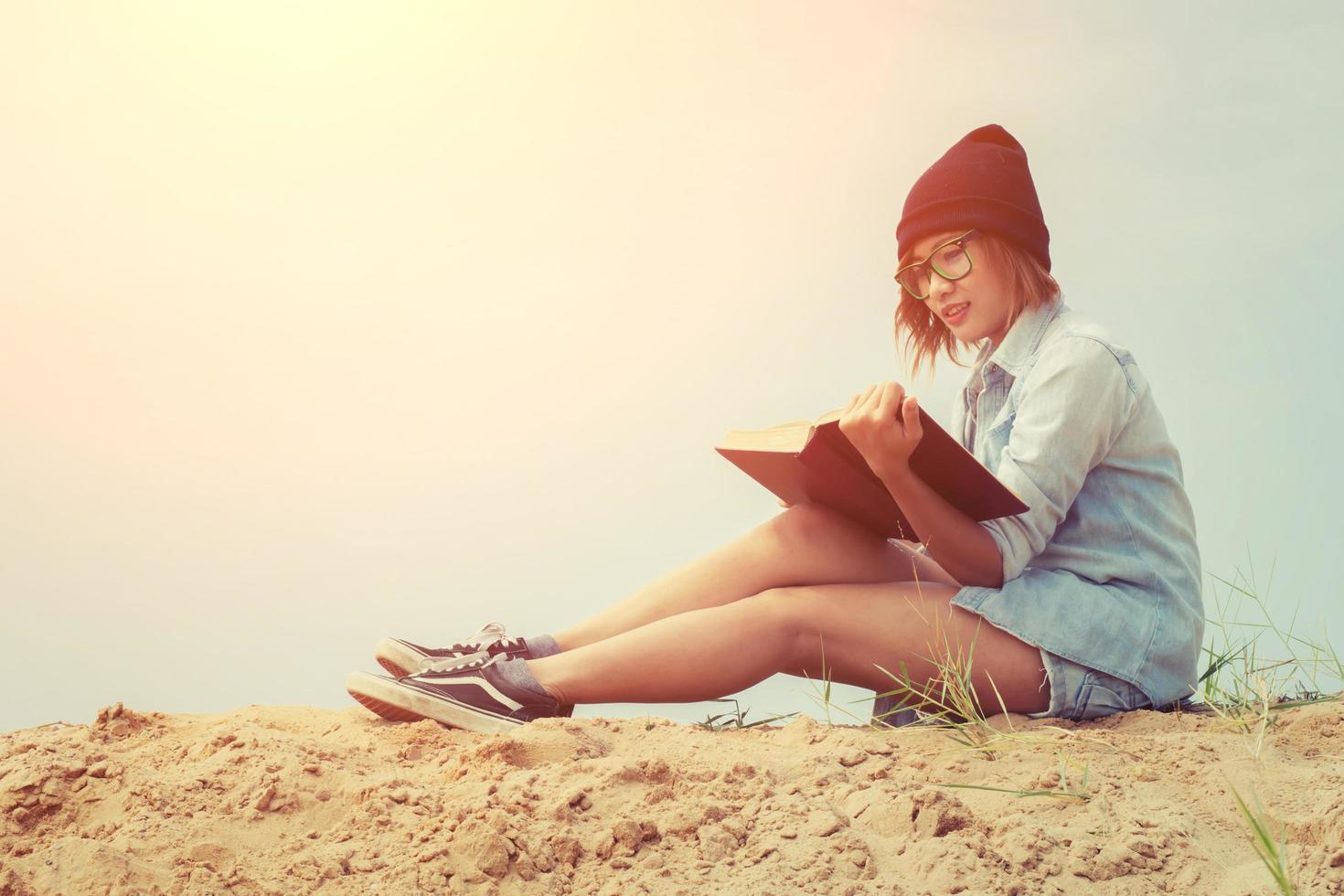 hermosa joven leyendo un libro en la playa foto