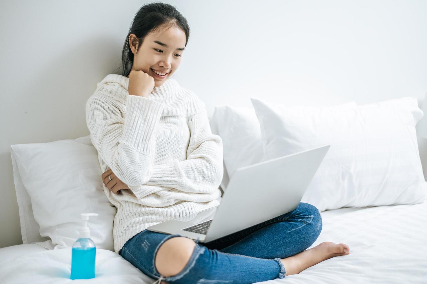 Young woman wearing a white shirt playing on her laptop photo