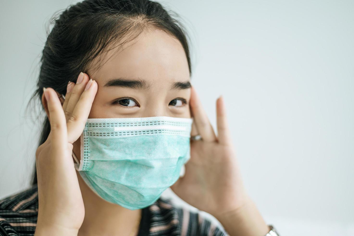 A woman wearing a striped shirt and a protective mask photo