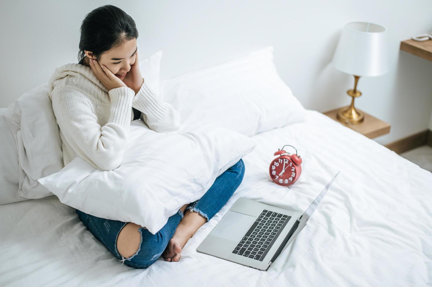 mujer joven feliz jugando en su computadora portátil foto