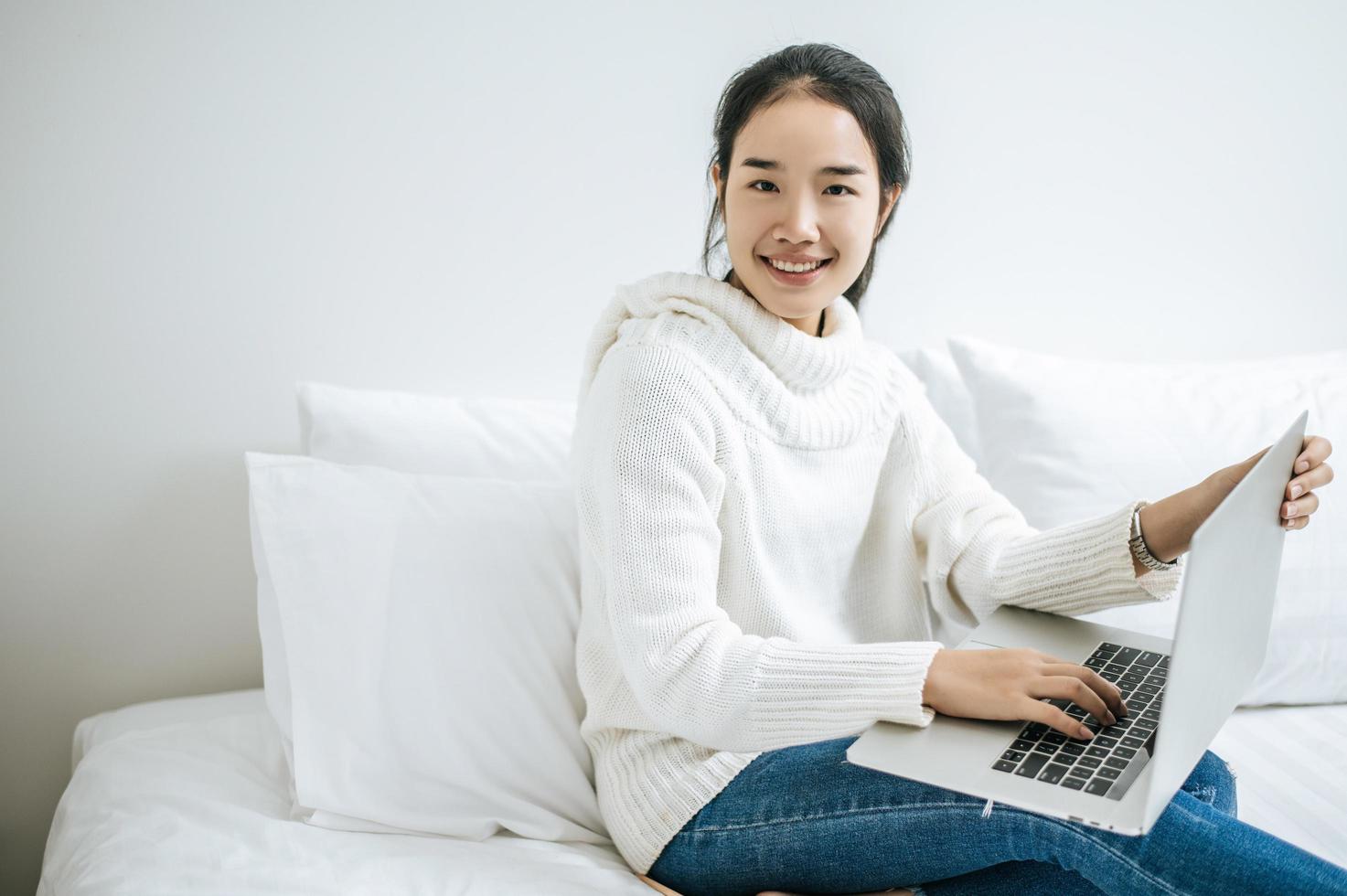 Young woman wearing a white shirt playing on her laptop photo