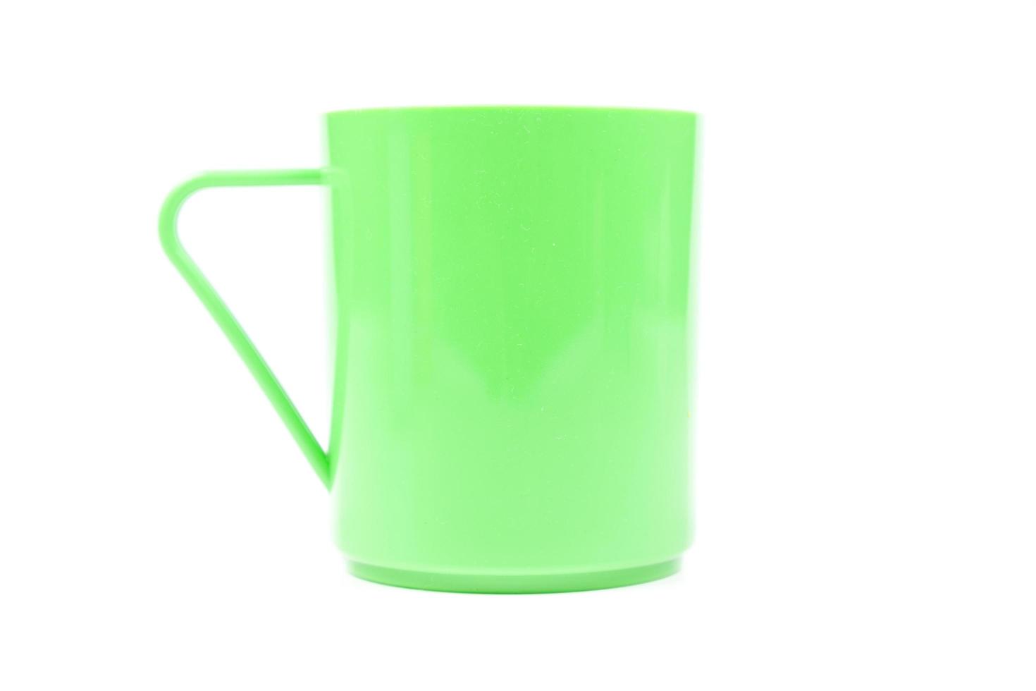 Vaso de plástico verde sobre fondo blanco. foto