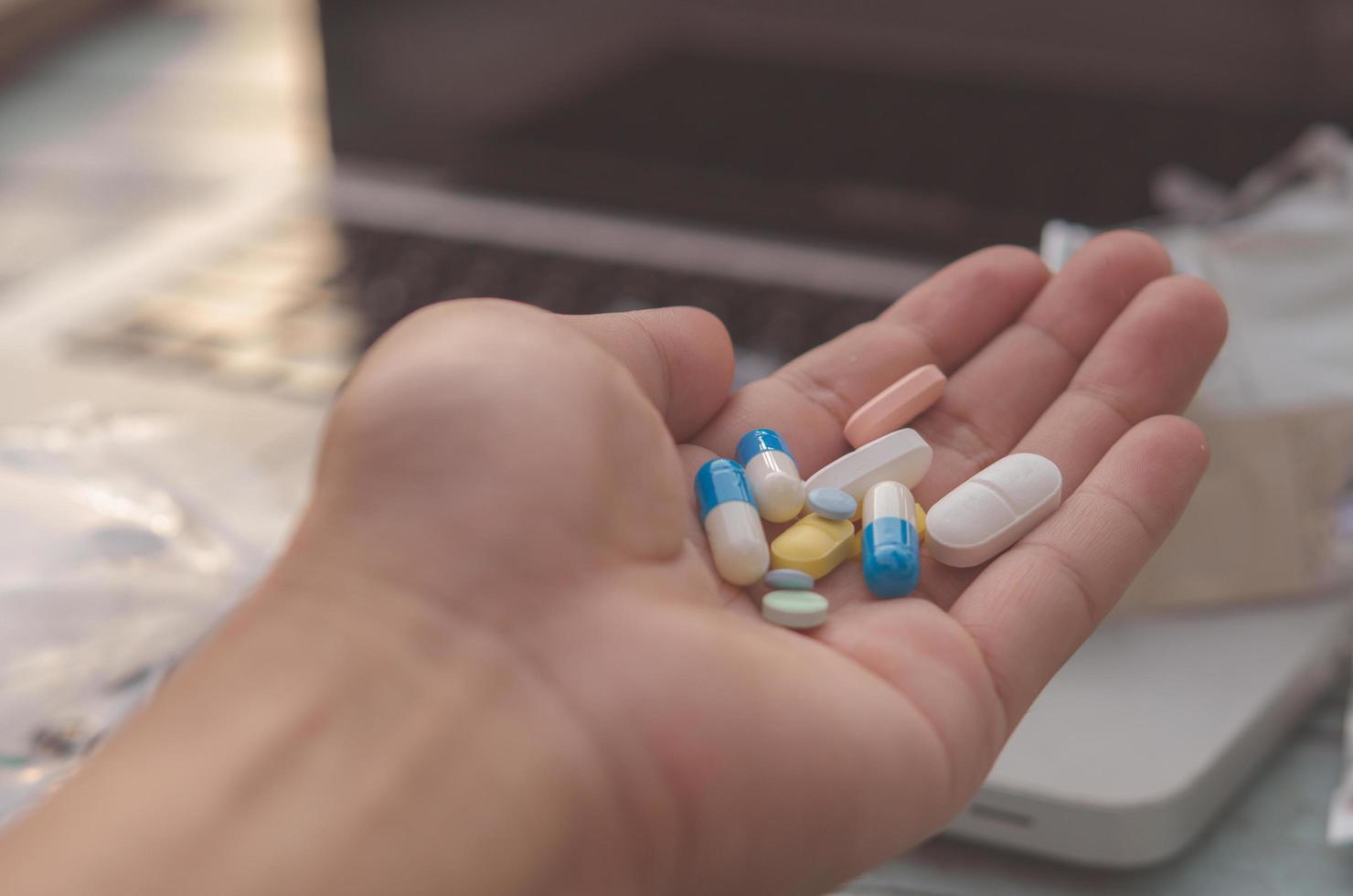 Lots of colorful pills in a hand photo