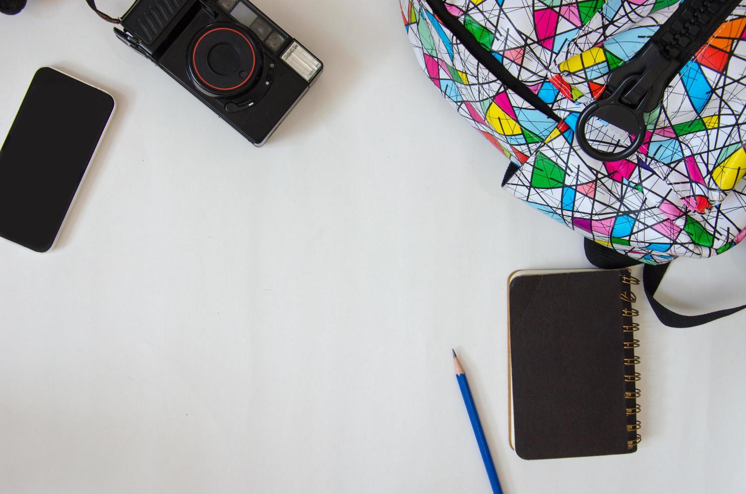 Backback, notebook, and camera on a table photo