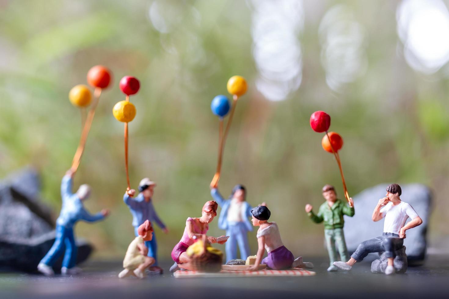 Group of miniature people having a picnic photo