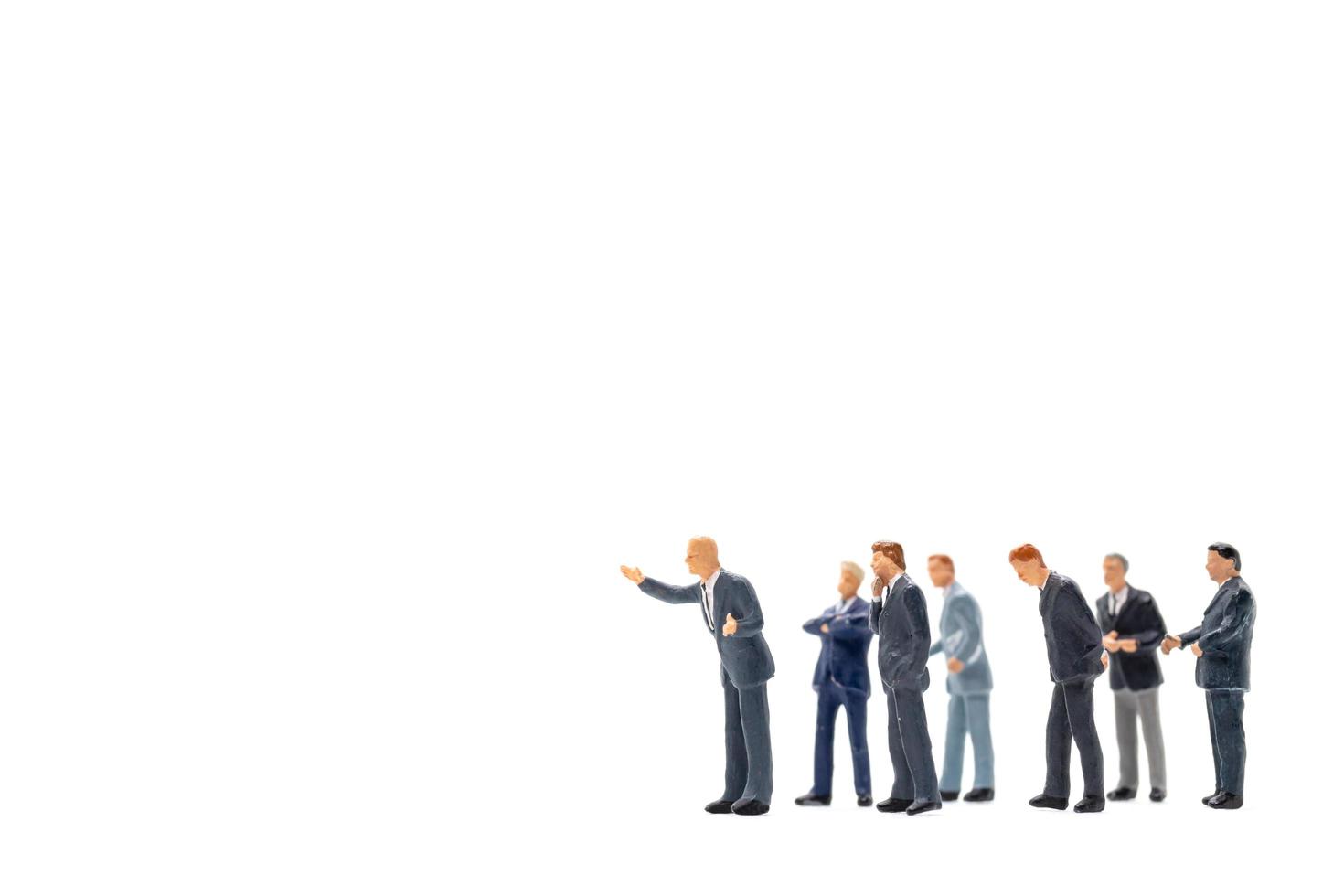 Miniature figurines of business people standing on white background photo