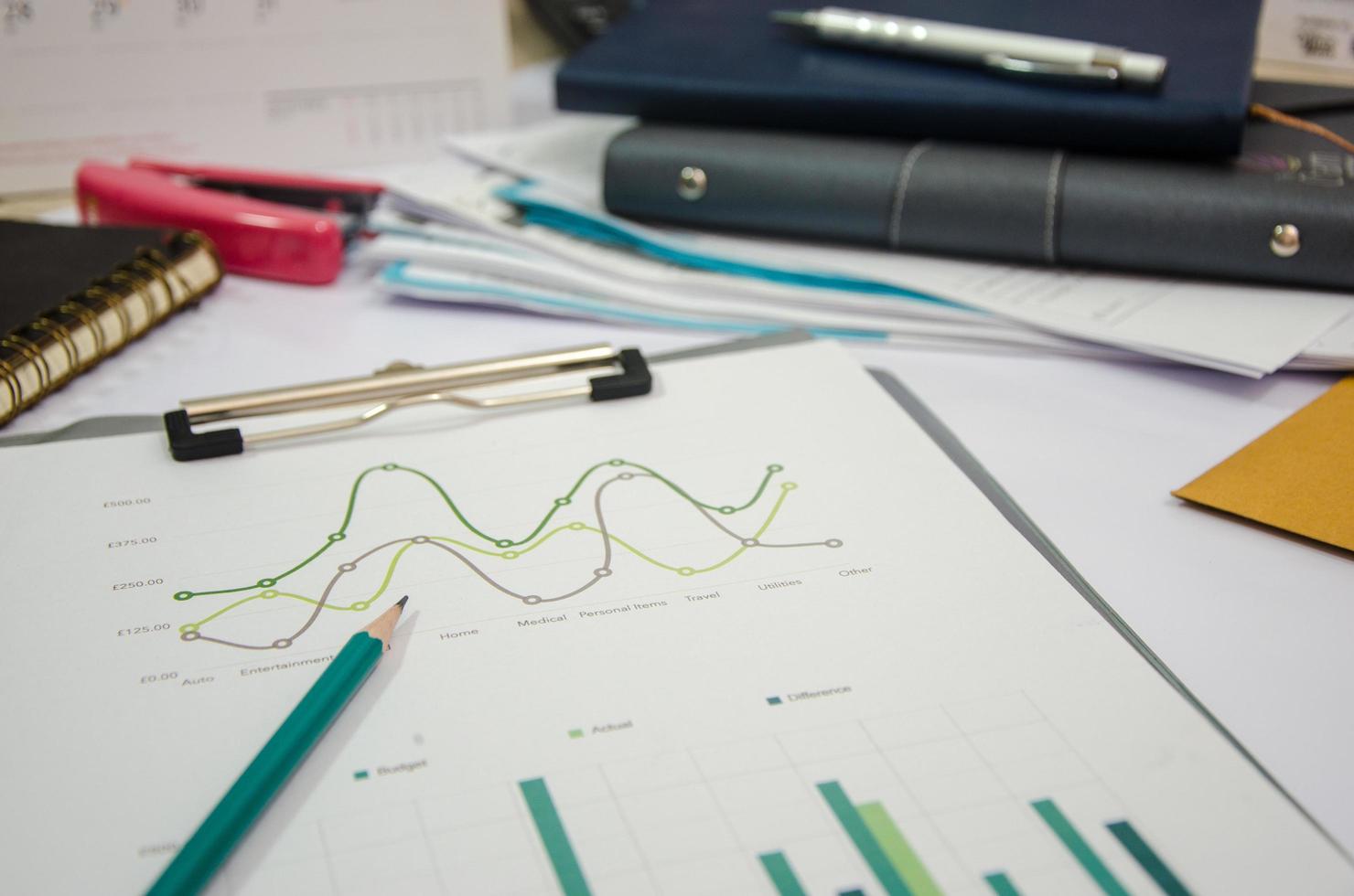 Messy desk with graph on a clip board photo