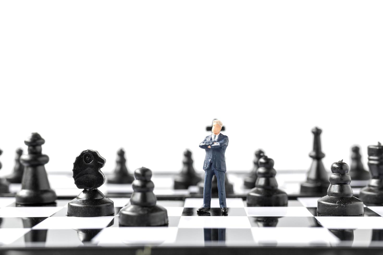 Miniature figurine of business person and a chessboard photo