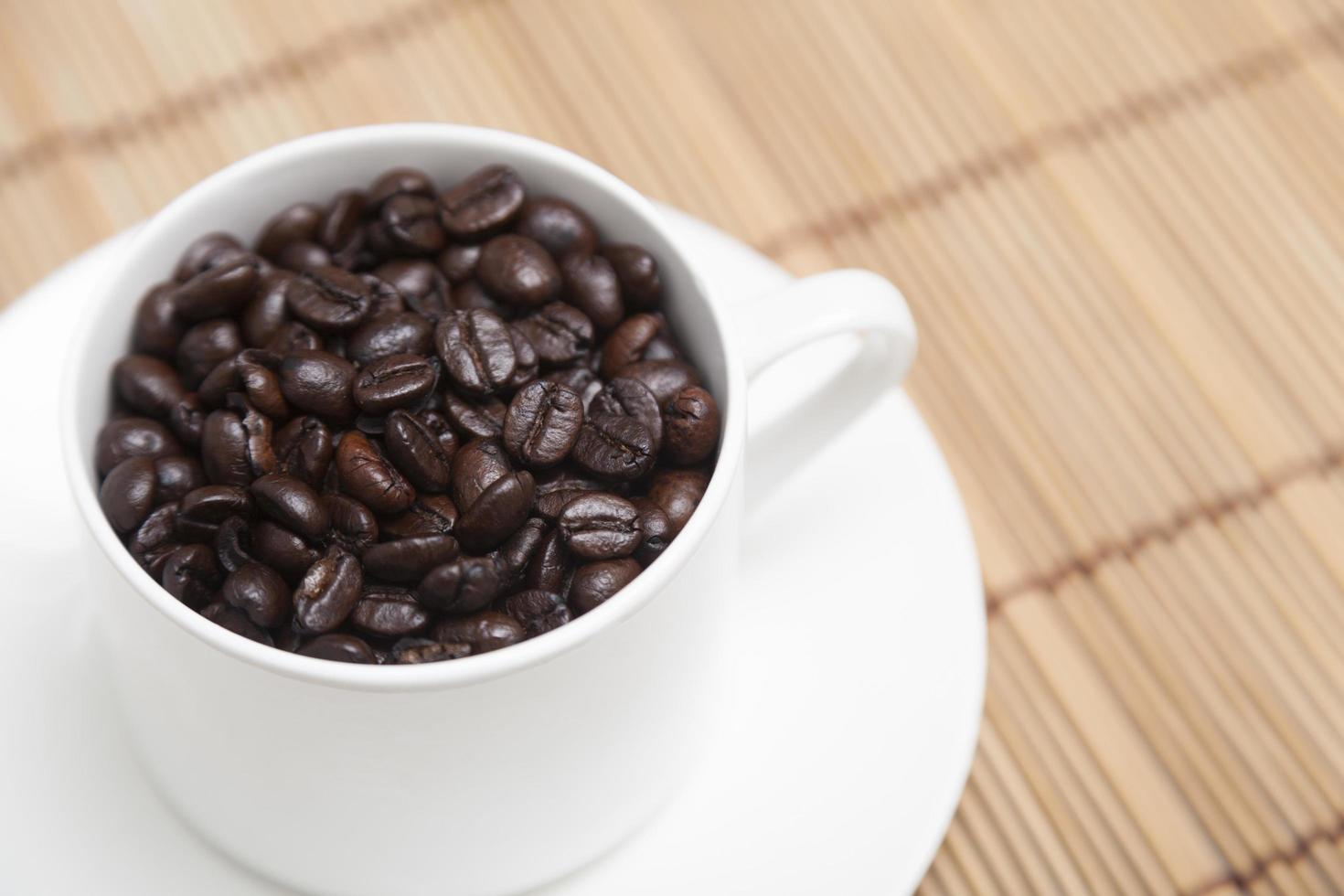 granos de café tostados en una taza foto