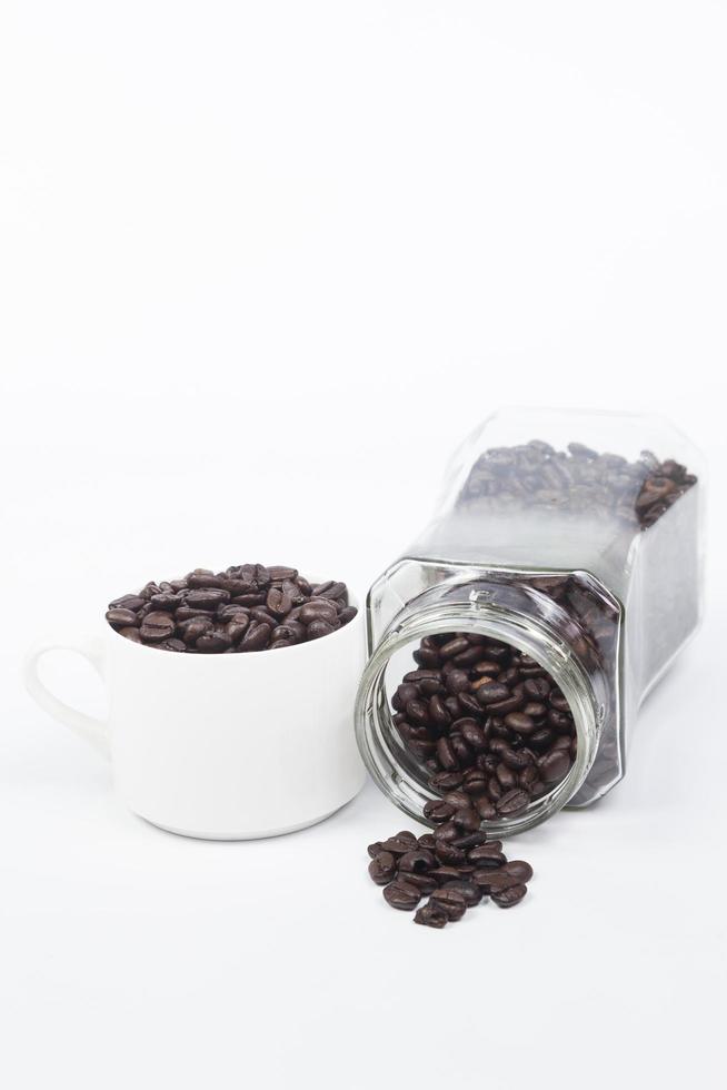 Taza con granos de café sobre fondo blanco. foto