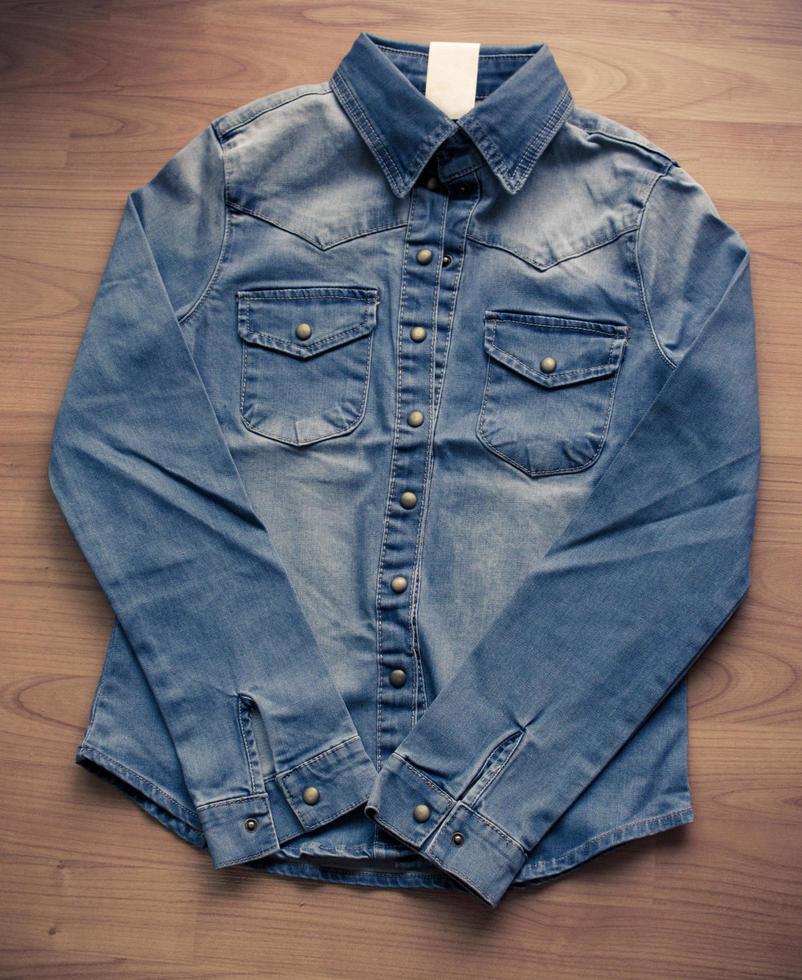 Blue denim shirt on wood floor photo