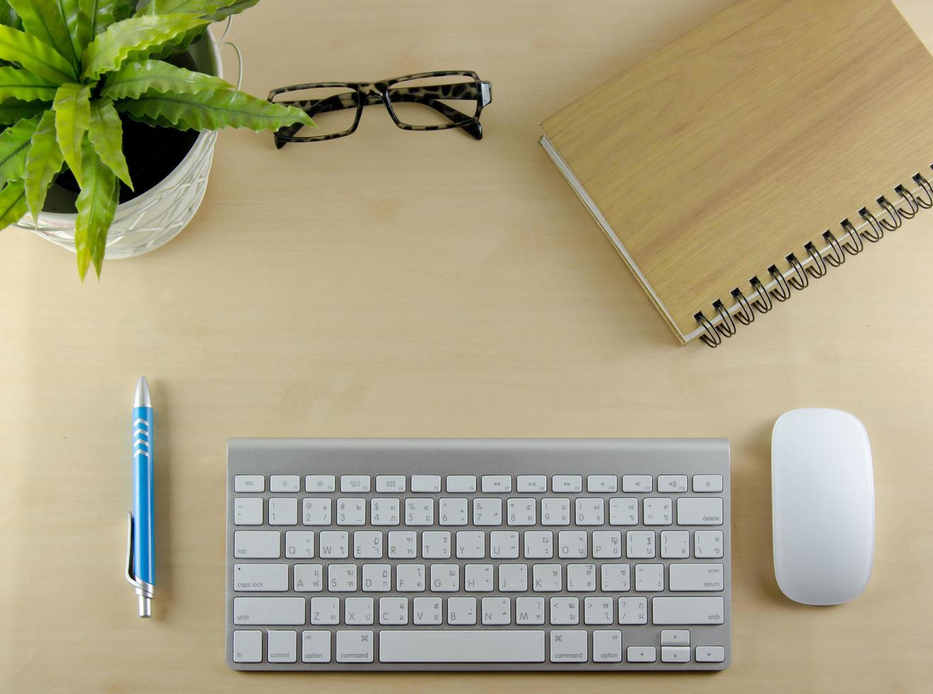 Keyboard, notebook, and mouse on desk photo