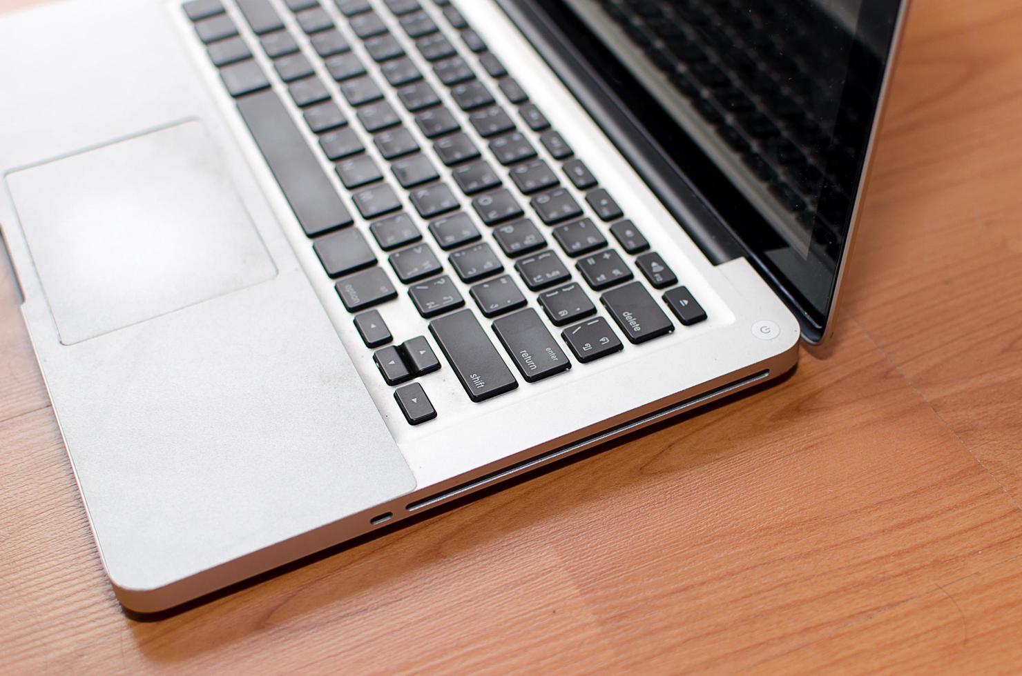 Corner of laptop on wooden desk photo