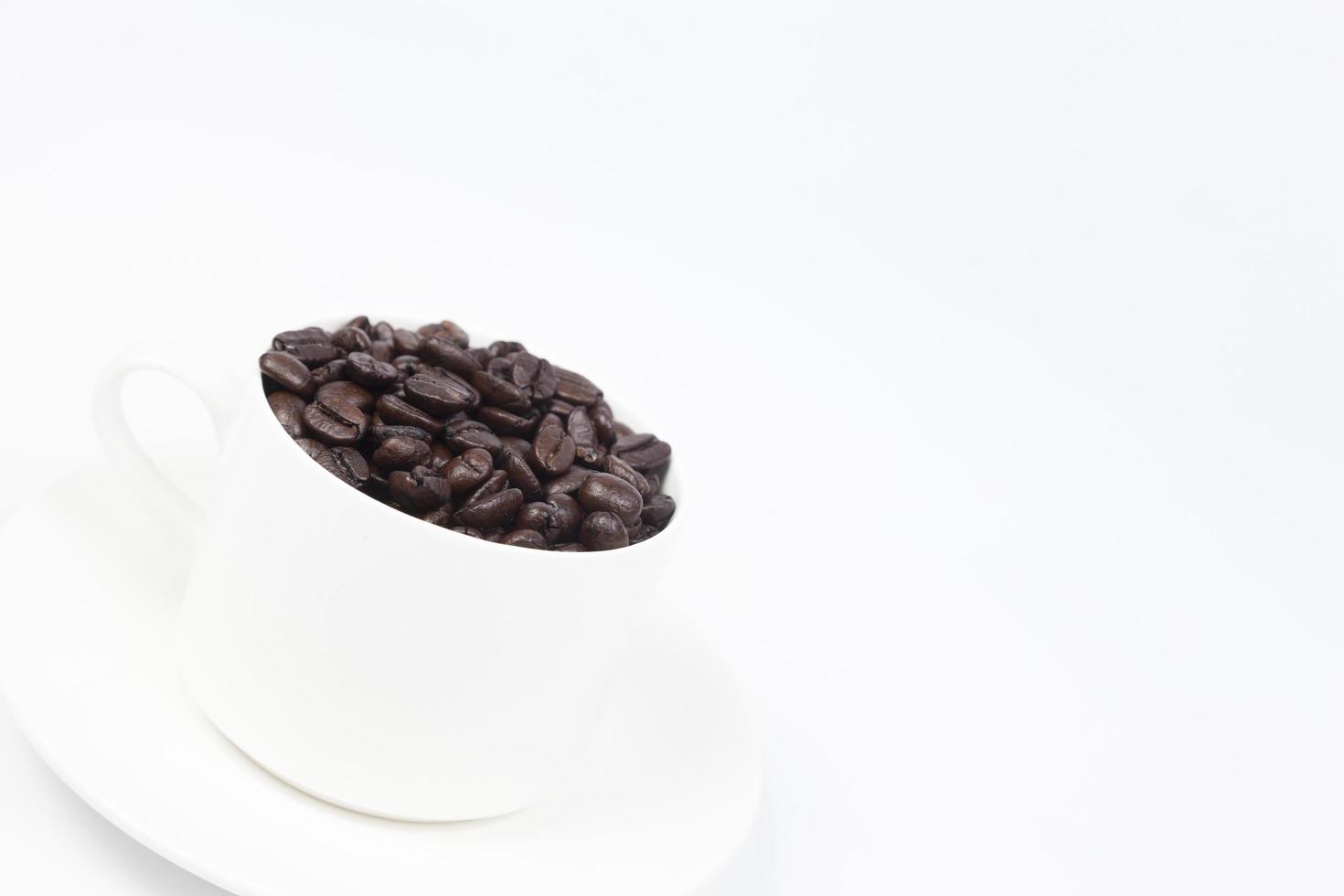 Cup with coffee beans on white background photo