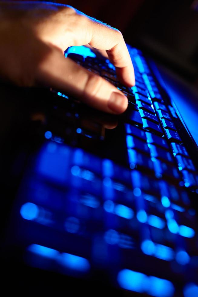 persona escribiendo en un teclado azul foto