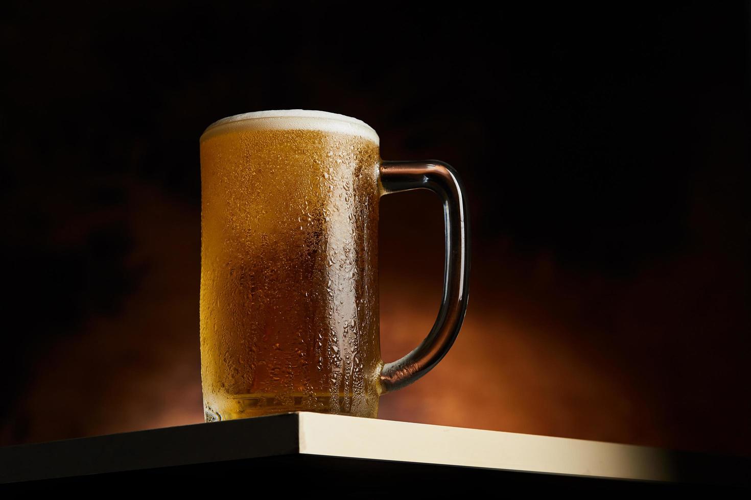 Beer in mug on a wooden table photo