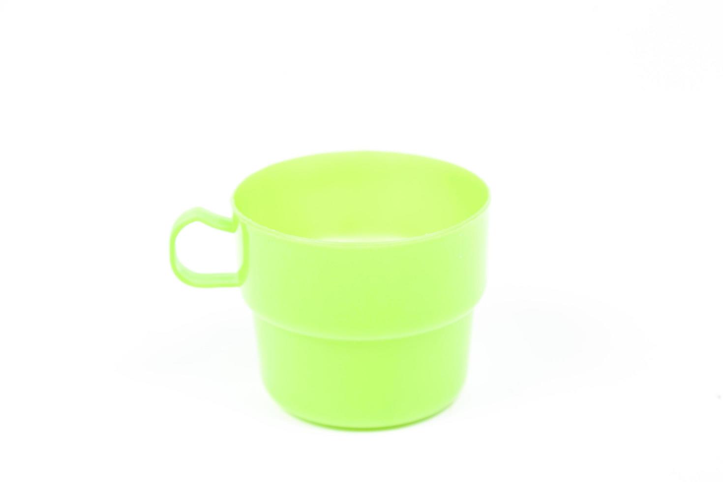 Vaso de plástico verde sobre fondo blanco. foto