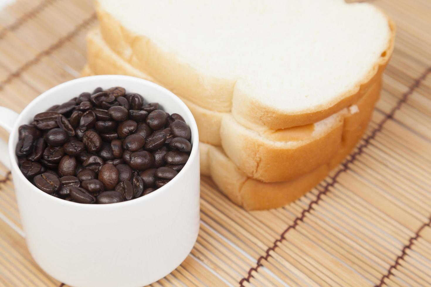 Bread and cup with coffee beans photo