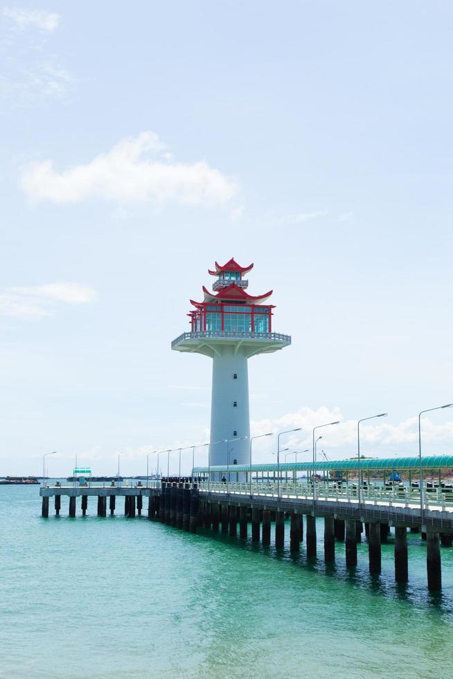 Lighthouse and bridge stretching into the sea photo