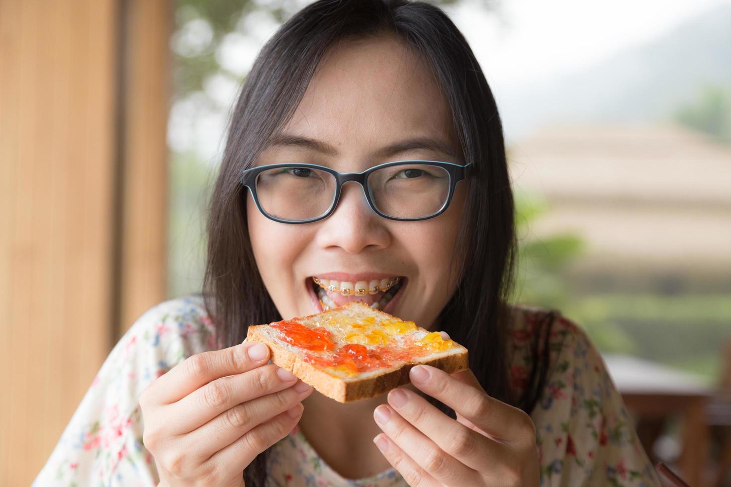 Thai woman eating bread with jam photo