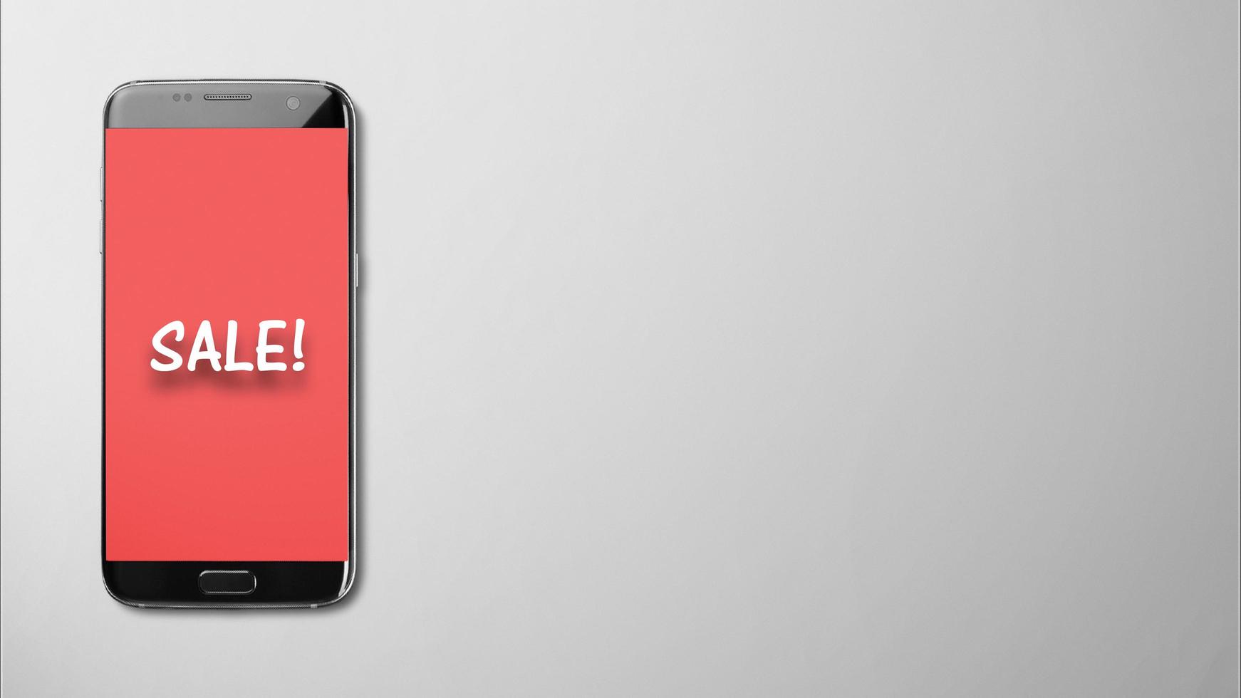 Sale text on red smartphone screen gray background photo