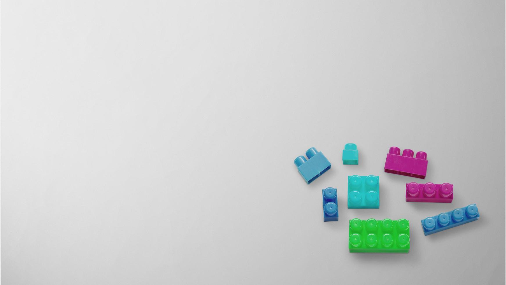 Colorful plastic building blocks on gray background photo