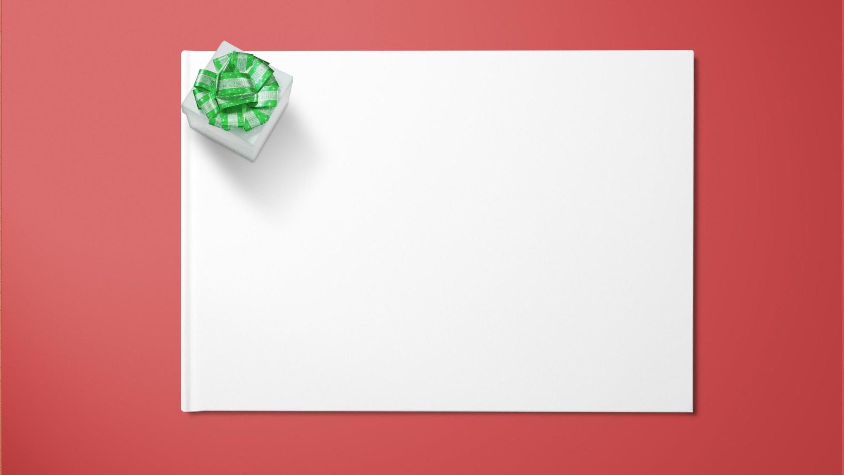 Gift box with green ribbon on white paper on red background photo