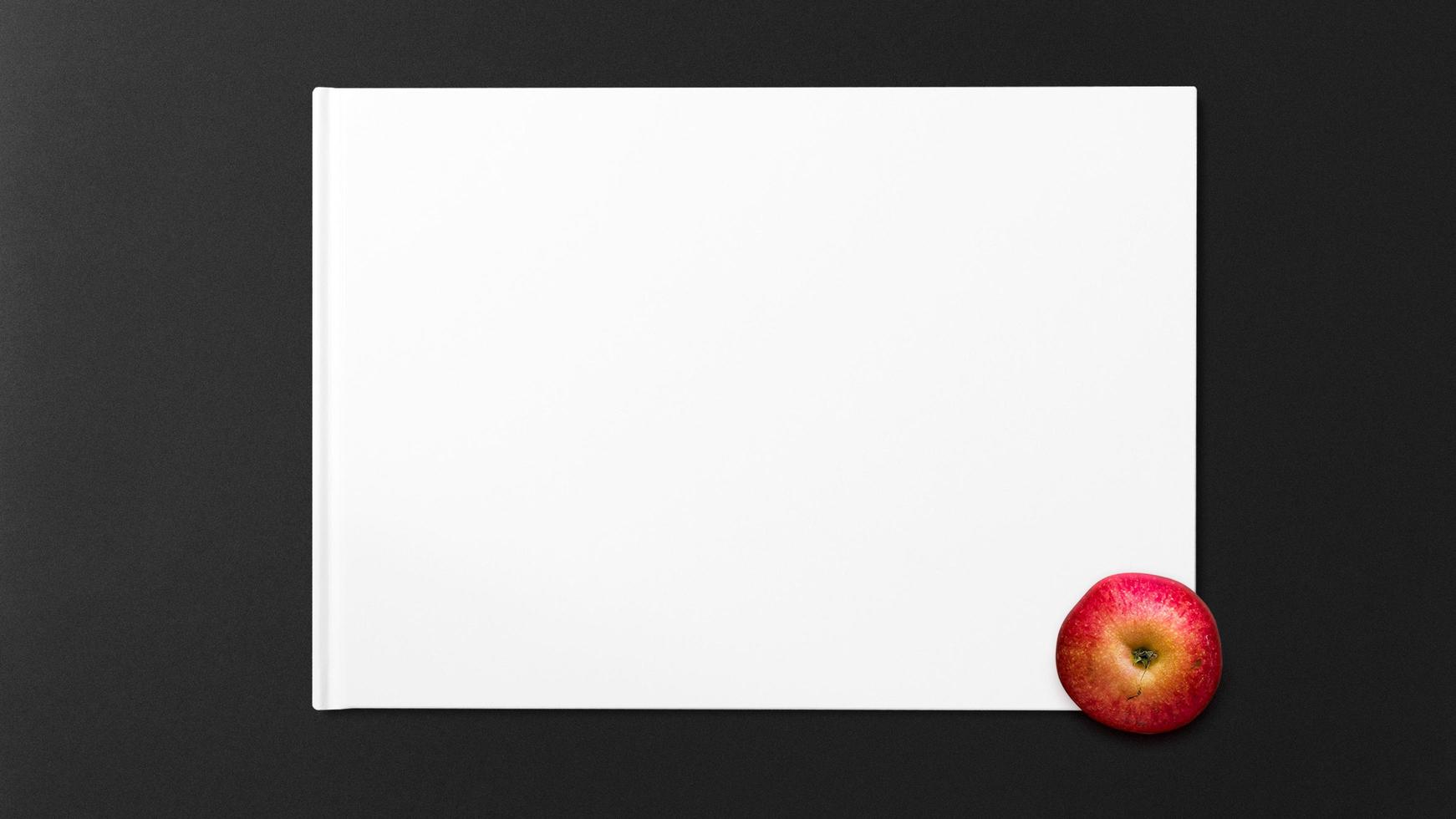Red apple on white paper on black background photo