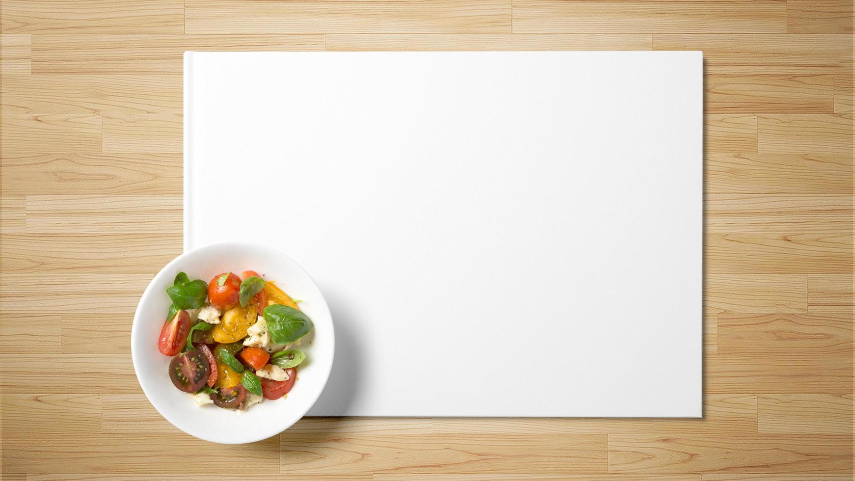 Ensalada de frutas sobre papel blanco sobre fondo de madera foto