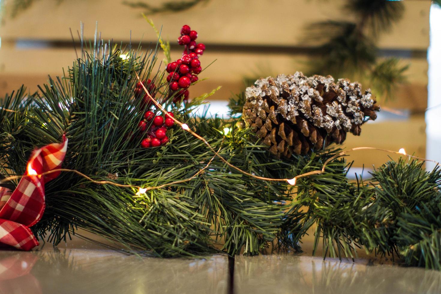 Pine cone and yellow string lights on Christmas tree branch photo
