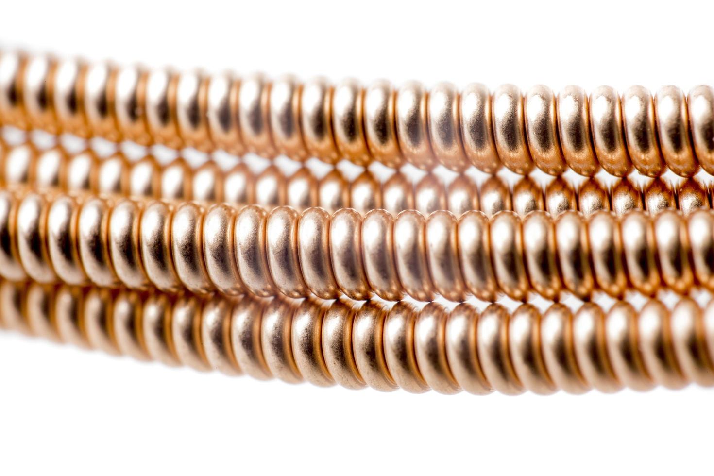 Close-up of ball end of bronze acoustic guitar string on white background photo