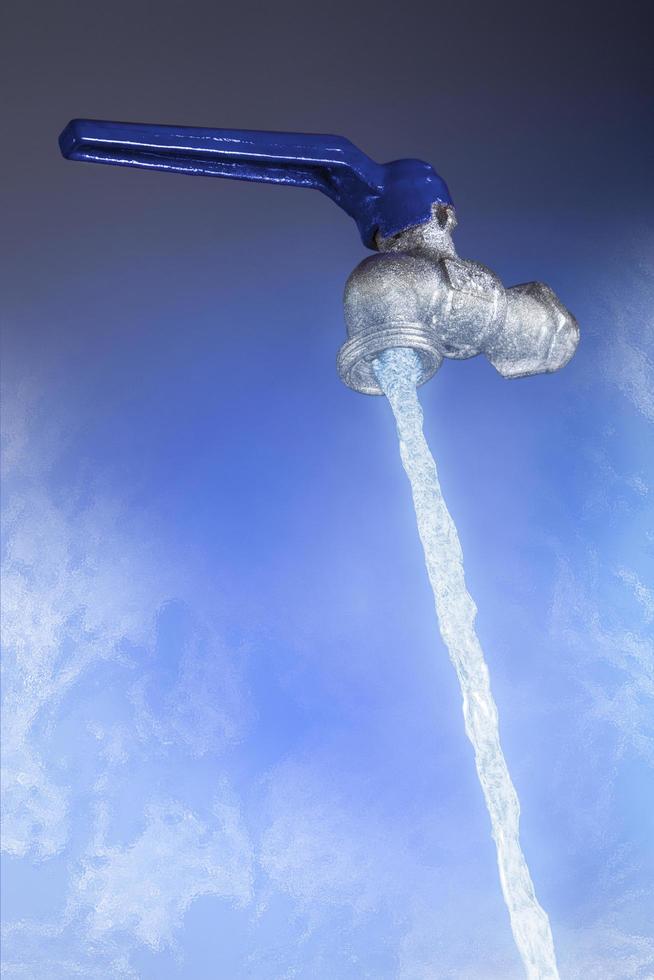 Agua que fluye del grifo con palanca azul sobre fondo azul. foto