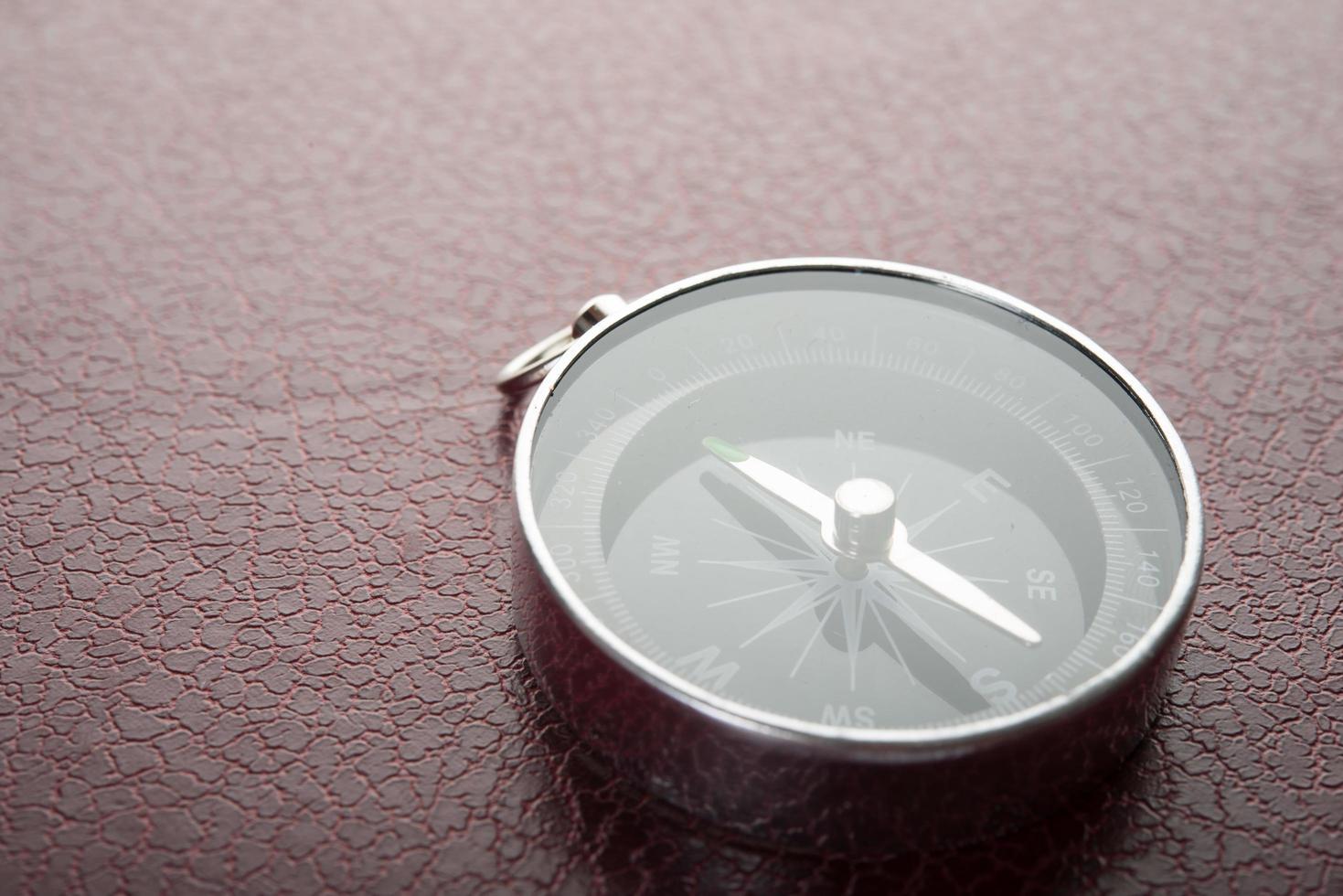 Compass on a red leather background photo