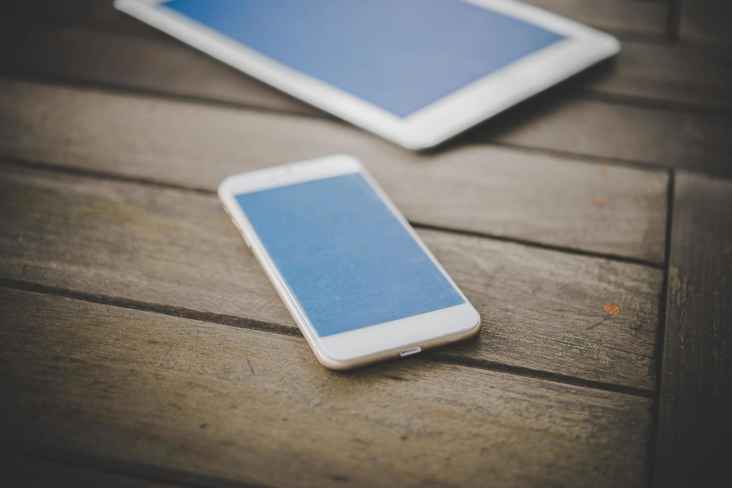 Smartphone and tablet on a wooden table photo