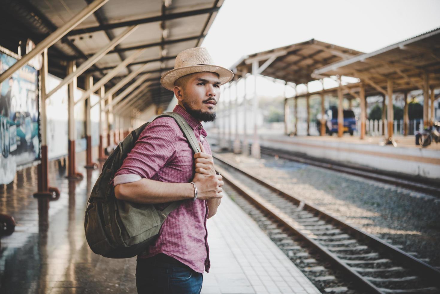 Young hipster man walking through train station photo