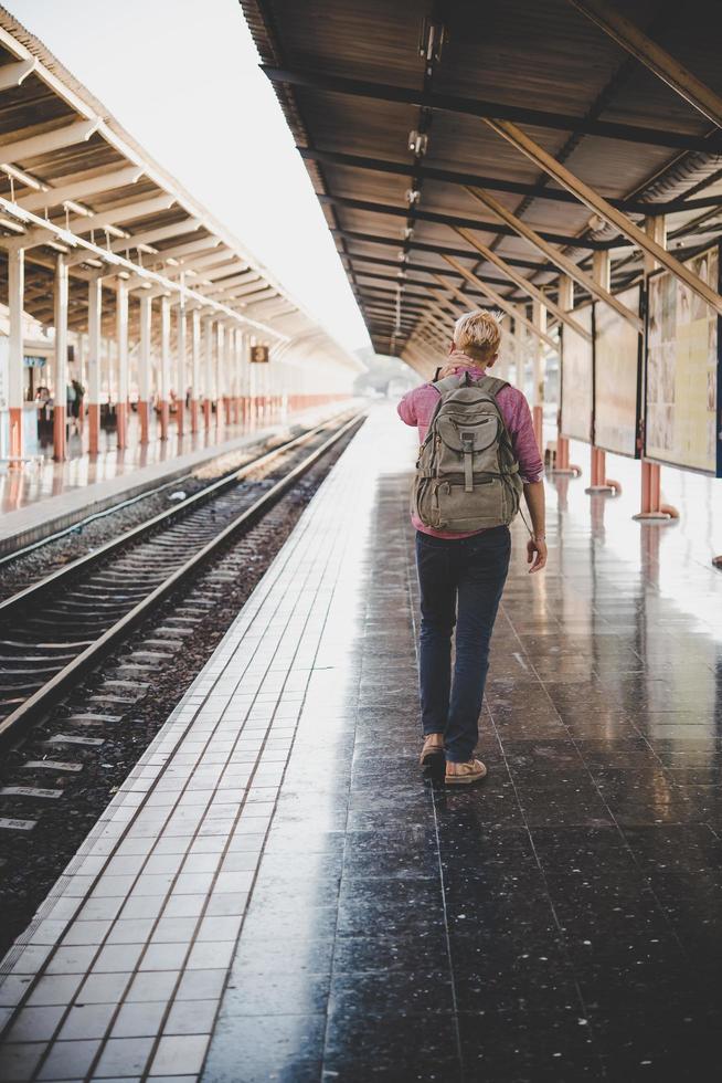 Young hipster man walking through train station photo