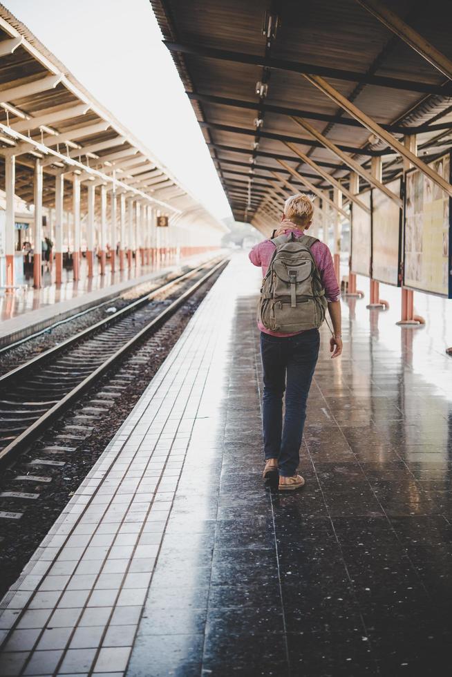 joven inconformista caminando por la estación de tren foto