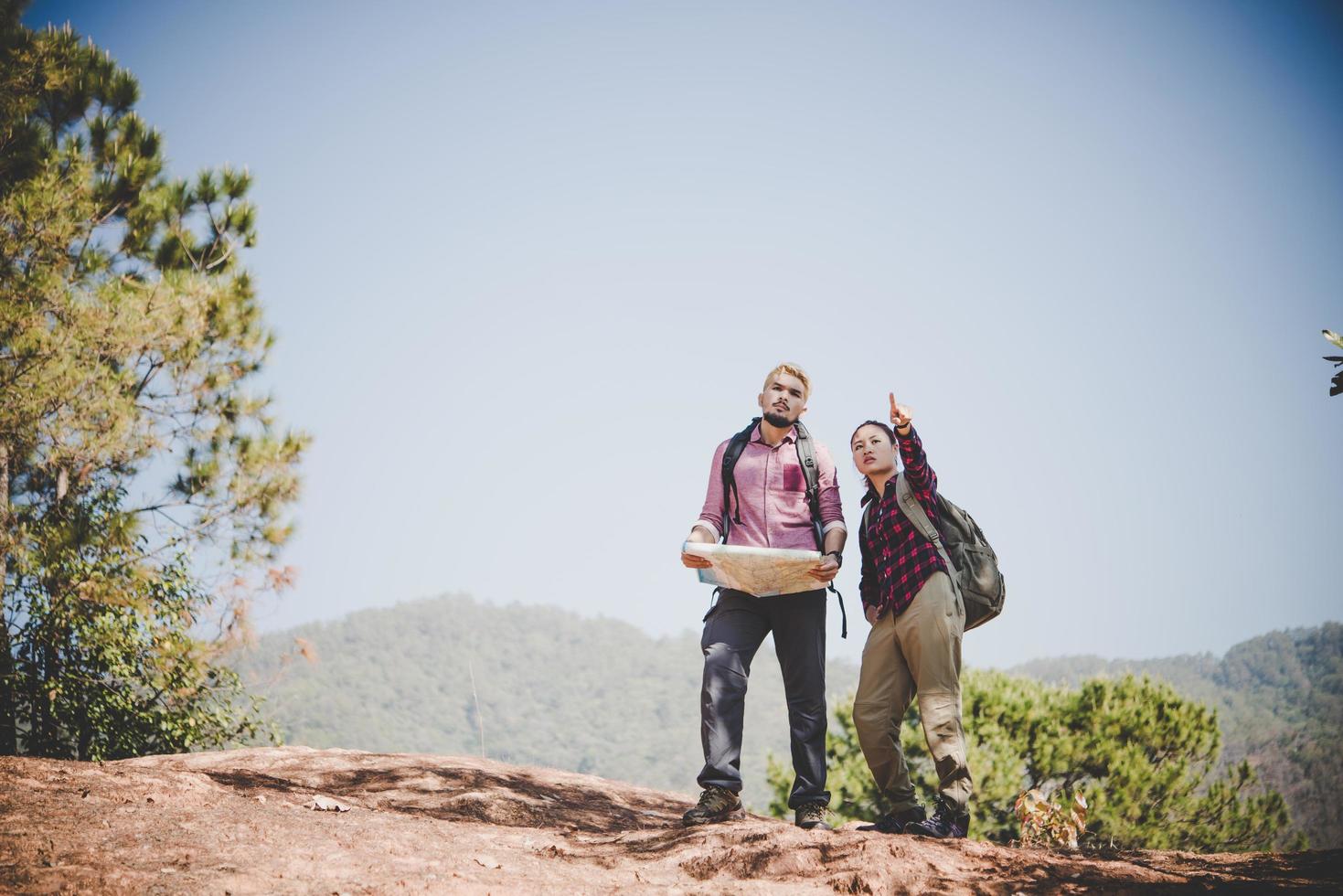 pareja de jóvenes turistas caminando a una montaña foto