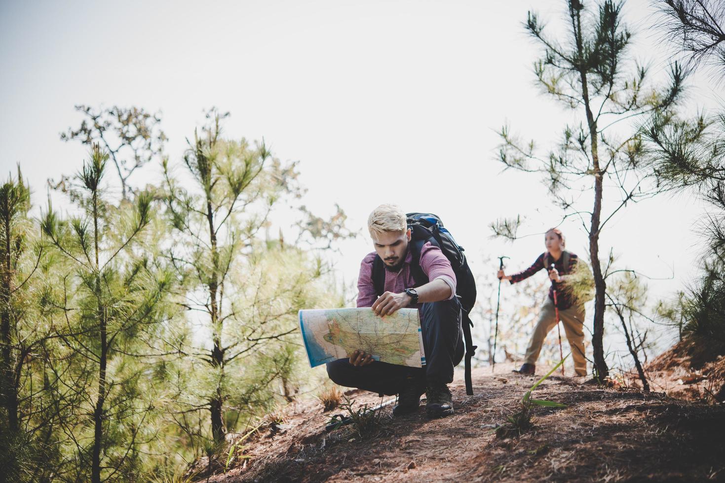 excursionista con mapa y gran mochila de viaje viajando a la montaña foto