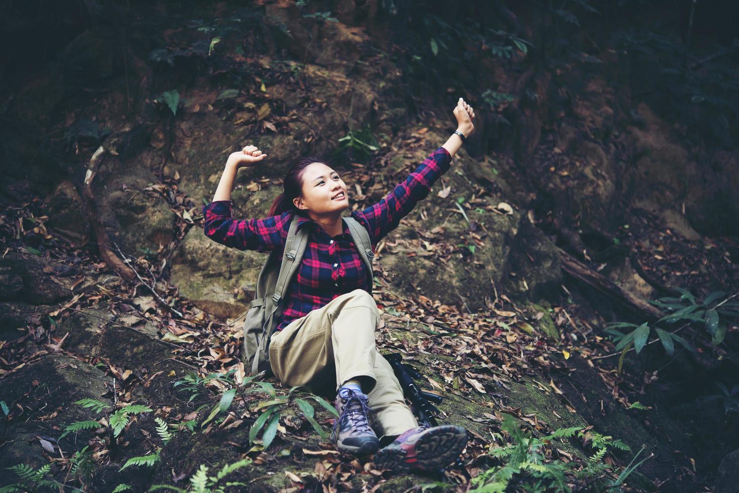 Mujer caminante en el bosque tomando un descanso foto