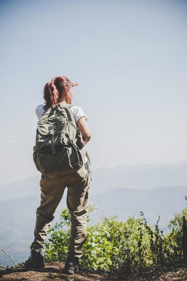 Mujer viajera con mochila en el hermoso paisaje de verano foto