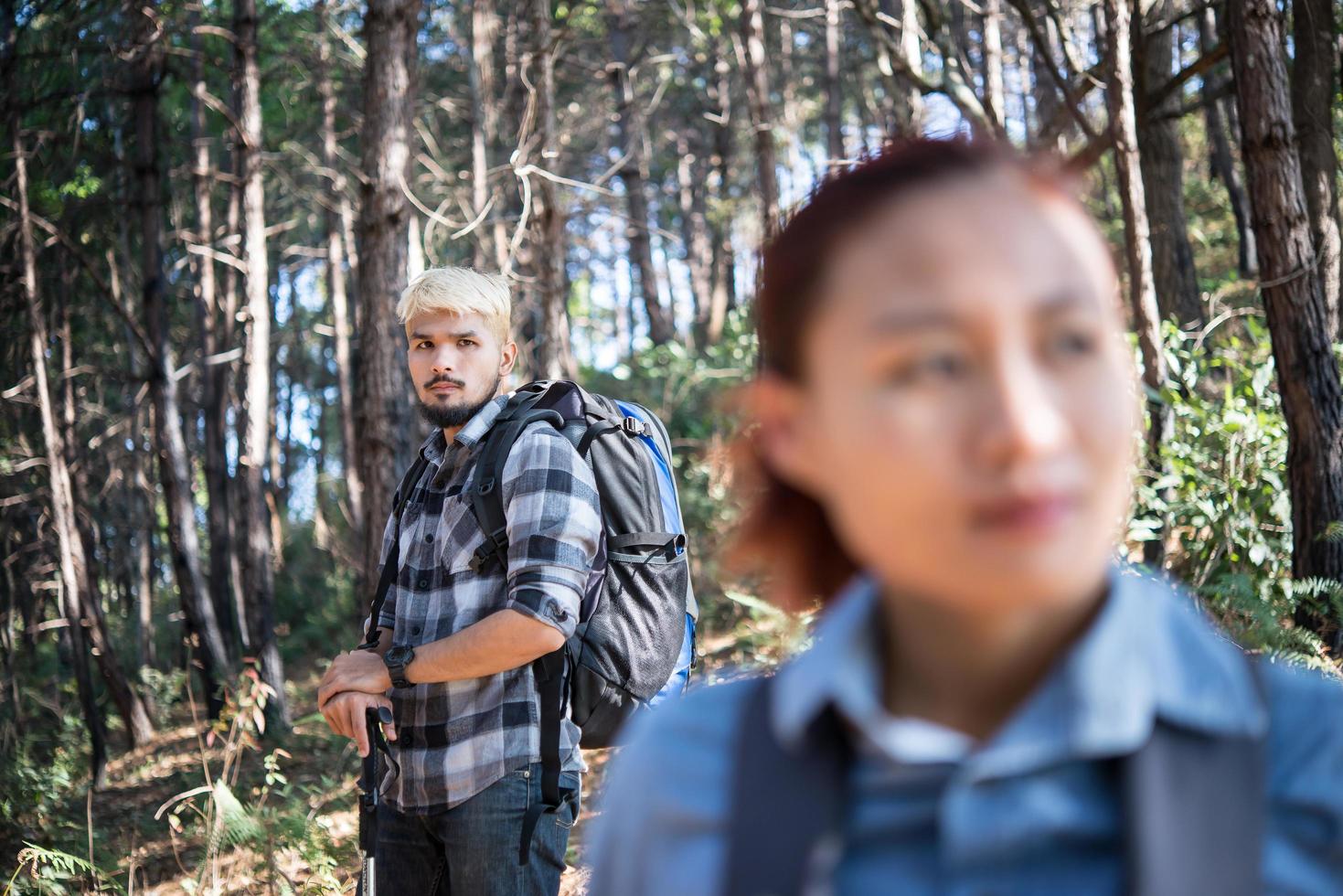 pareja de excursionistas mochileros en el bosque de pinos foto
